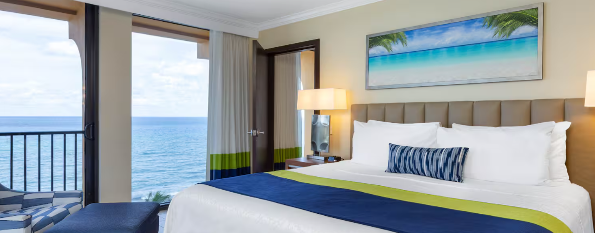 Oceanfront guest room with a king bed and a private balcony overlooking the water