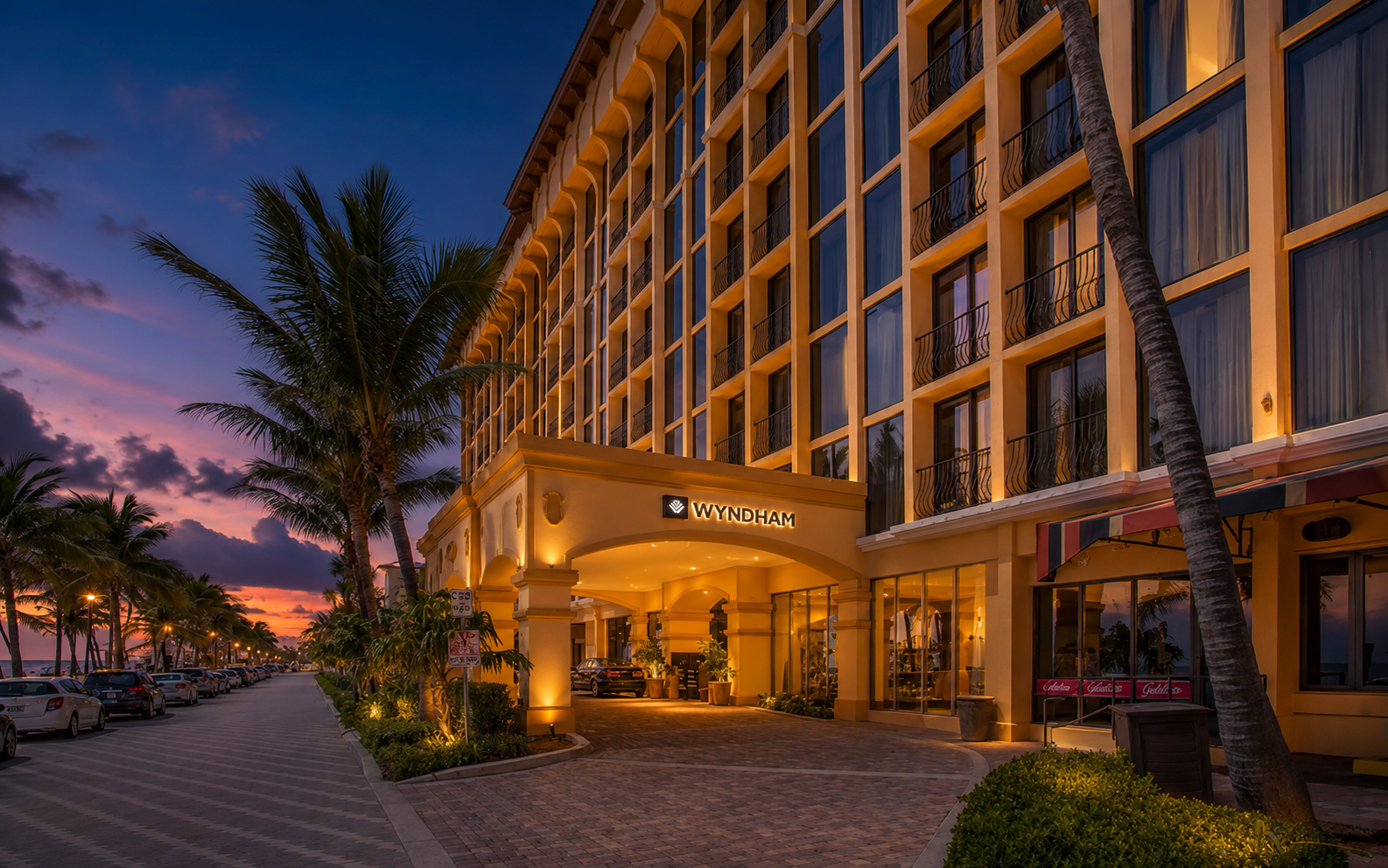 Wyndham hotel entrance illuminated at dusk with palm trees